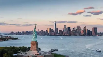 a view of the statue of liberty in front of a city at Stylish 2 BD Apt-18 mins from NYC-Steps away Bus stop, Restaurants, Groceries in Jersey City