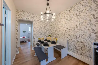 a dining room with a white table and a patterned wall at Stylish 2 BD Apt-18 mins from NYC-Steps away Bus stop, Restaurants, Groceries in Jersey City