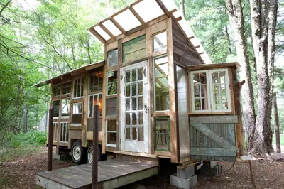 a tiny house on a truck in the woods at The Outlier Inn in Woodridge