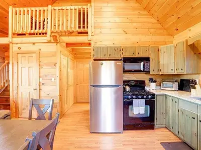 a kitchen with a stainless steel refrigerator in a wooden cabin at Haven View Retreat in White Haven