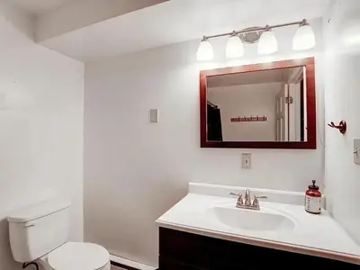 a bathroom with a toilet and a sink and a mirror at Haven View Retreat in White Haven
