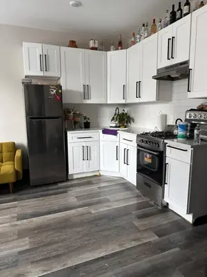 a kitchen with white cabinets and a black refrigerator at Oasis de comodidad Habitación individual o compartida in Jersey City