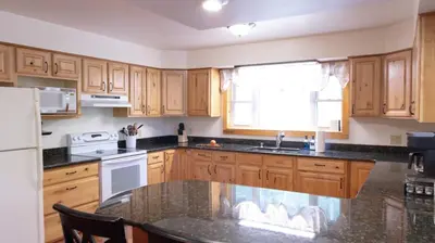 a kitchen with wooden cabinets and a sink and a window at Cammalot - Pine Creek Valley