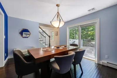 a dining room with a wooden table and chairs at Zen Lake House in Greenwood Lake