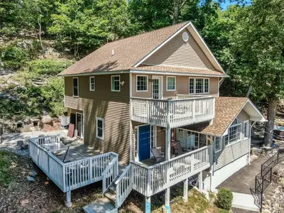 a house with white railings and a porch at Zen Lake House in Greenwood Lake