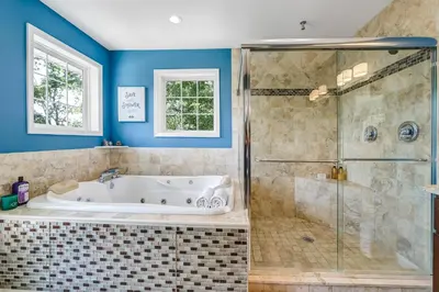 a bathroom with a tub and a glass shower at Zen Lake House in Greenwood Lake