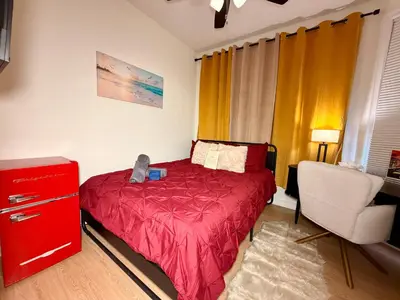 a bedroom with a red bed and a chair at BP STAYS - Hotel-Style, No Host, Professionally Managed ID247 in Jersey City