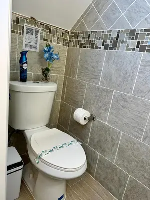 a bathroom with a toilet and a tiled wall at BP STAYS - Hotel-Style, No Host, Professionally Managed ID247 in Jersey City