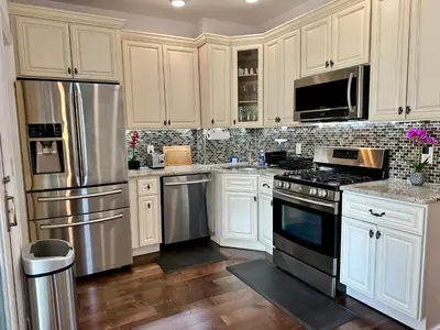 a kitchen with white cabinets and stainless steel appliances at BP STAYS - Hotel-Style, No Host, Professionally Managed ID247 in Jersey City