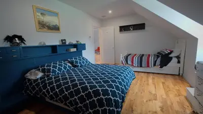 a bedroom with a bed with a blue comforter at Carpathia West Estate in West Milford