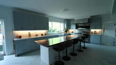 a kitchen with blue cabinets and a island with bar stools at Carpathia West Estate in West Milford
