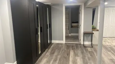a hallway with black doors and wood floors at Fantastic Studio in North Bergen