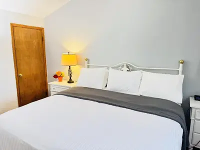 a bedroom with a white bed and a lamp at Pocono Ridge Inn East Stroudsburg - Poconos in East Stroudsburg