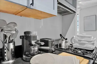a kitchen with a stove and a counter top with dishes at Stylish 3BR-2BA in Gramercy -Modern & Central in New York