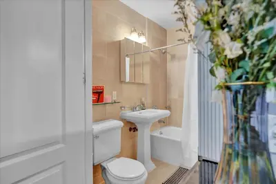 a bathroom with a toilet and a sink and a tub at Stylish 3BR-2BA in Gramercy -Modern & Central in New York