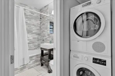 a washer and dryer in a bathroom with a sink at Modern 2BR with Private Garden In Gramercy Park in New York