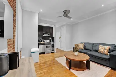 a living room with a couch and a table at Modern 2BR with Private Garden In Gramercy Park in New York