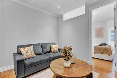 a living room with a couch and a table at Modern 2BR with Private Garden In Gramercy Park in New York
