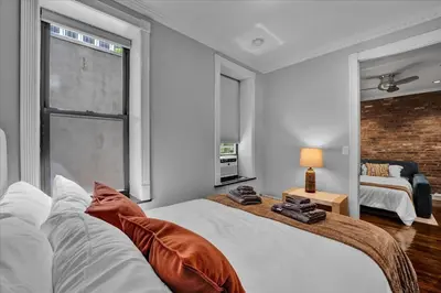 a bedroom with a bed and a brick wall at Stylish 3BR-2BA in Gramercy in New York