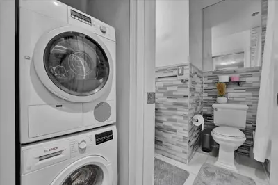 a washer and dryer in a bathroom with a toilet at Stylish 3BR-2BA in Gramercy in New York