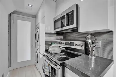 a kitchen with a stove and a microwave at SoHo Designer 2BR w balcony in New York