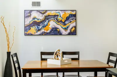 a dining room table with a picture on the wall at Modern 3BR Townhouse with Private Rooftop & Parking Minutes to NYC in Hoboken