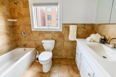 a bathroom with a toilet and a tub and a sink at Modern 3BR Townhouse with Private Rooftop & Parking Minutes to NYC in Hoboken