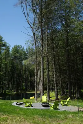 a group of picnic tables and chairs in a park at Luxe Modern Cabin with Pond, Fire Pit, Hiking, near Bethel Woods in Narrowsburg