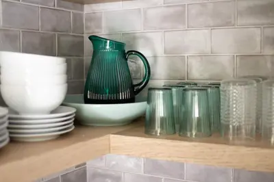 a shelf with plates and a green pitcher and cups at Fire Pit, Private & Stylish Birdsong Schoolhouse in Barryville