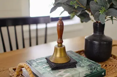 a small figurine on a table with a book and a vase at Fire Pit, Private & Stylish Birdsong Schoolhouse in Barryville