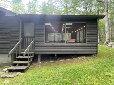 a black tiny house with a staircase in a yard at Fire Pit Woodsy & Private - Cabin on Woods Road in Yulan