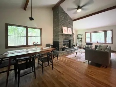 a living room with a dining table and a fireplace at Fire Pit Woodsy & Private - Cabin on Woods Road in Yulan