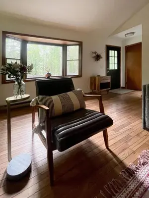 a living room with a leather chair and a couch at Fire Pit Woodsy & Private - Cabin on Woods Road in Yulan