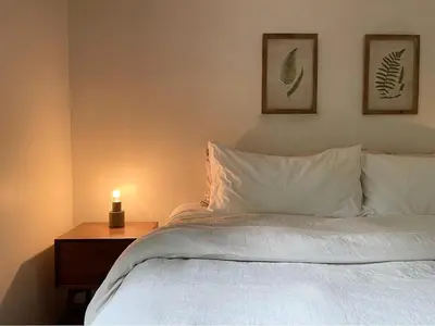 a bedroom with a bed with a candle on a table at Fire Pit Woodsy & Private - Cabin on Woods Road in Yulan