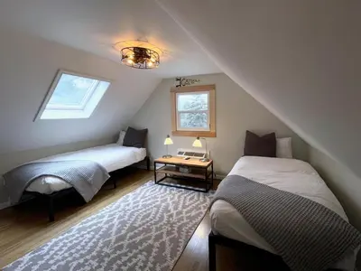 a attic bedroom with two beds and a table at Lake House, Fire Pit, Games Magnolia Lake House in Ferndale