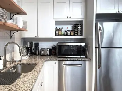 a kitchen with white cabinets and a stainless steel refrigerator at Lake House, Fire Pit, Games Magnolia Lake House in Ferndale