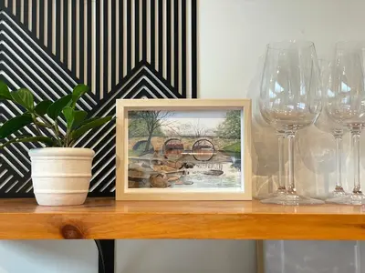 a picture on a table with glasses and a plant at Lake House, Fire Pit, Games Magnolia Lake House in Ferndale