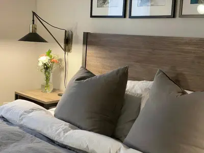a bed with pillows and a table with a vase of flowers at Lake House, Fire Pit, Games Magnolia Lake House in Ferndale