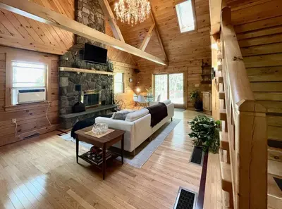 a living room with a couch and a stone fireplace at Red Tail Ridge in North Branch