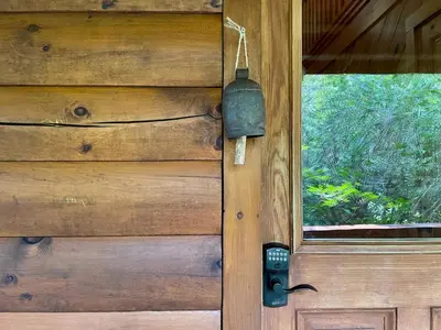 a wooden door with a bell on it with a window at Red Tail Ridge in North Branch