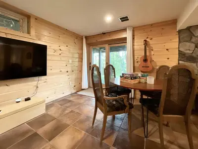 a dining room with a table and a flat screen tv at Red Tail Ridge in North Branch
