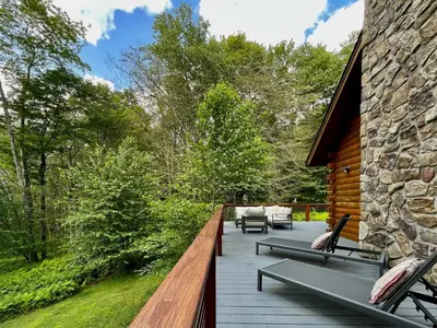 a wooden deck with chairs and a building at Red Tail Ridge in North Branch