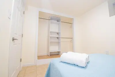 a white room with a bed with a towel on it at Cozy 1 Bedroom Apt - Minutes to NYC - Great for Remote Work in North Bergen