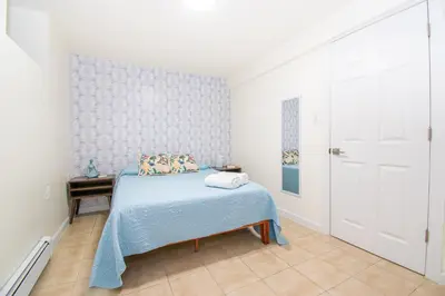 a bedroom with a bed with a blue blanket at Cozy 1 Bedroom Apt - Minutes to NYC - Great for Remote Work in North Bergen