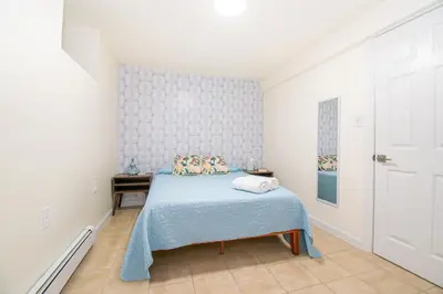 a bedroom with a bed with a blue blanket at Cozy 1 Bedroom Apt - Minutes to NYC - Great for Remote Work in North Bergen