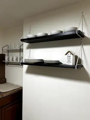 a kitchen with a shelf with dishes on it at Cozy 1 Bedroom Apt - Minutes to NYC - Great for Remote Work in North Bergen
