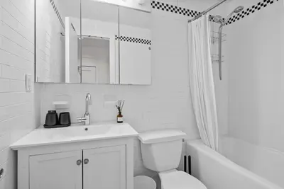 a white bathroom with a toilet and a sink at Stylish Manhattan Escape in Prime Spot in New York