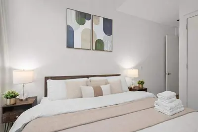 a bedroom with a large white bed with two lamps at Stylish Manhattan Escape in Prime Spot in New York