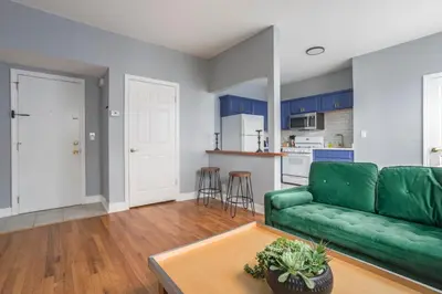 a living room with a green couch and a table at One BR near Metlife with Laundry & Parking in Lodi
