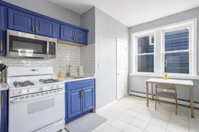 a kitchen with blue cabinets and a white stove at One BR near Metlife with Laundry & Parking in Lodi